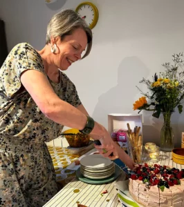 Kate Stevens smiling, cutting a birthday cake