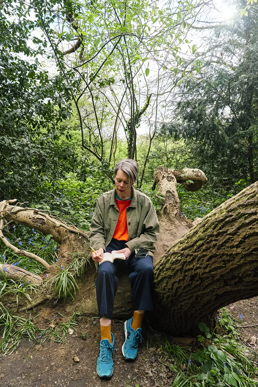 Kate, known as The KateOutdoors Life Coach, writing in her book in a woodland setting