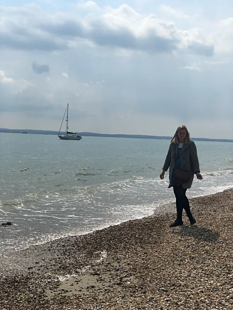 Confidant woman on the beach with boat by the ea