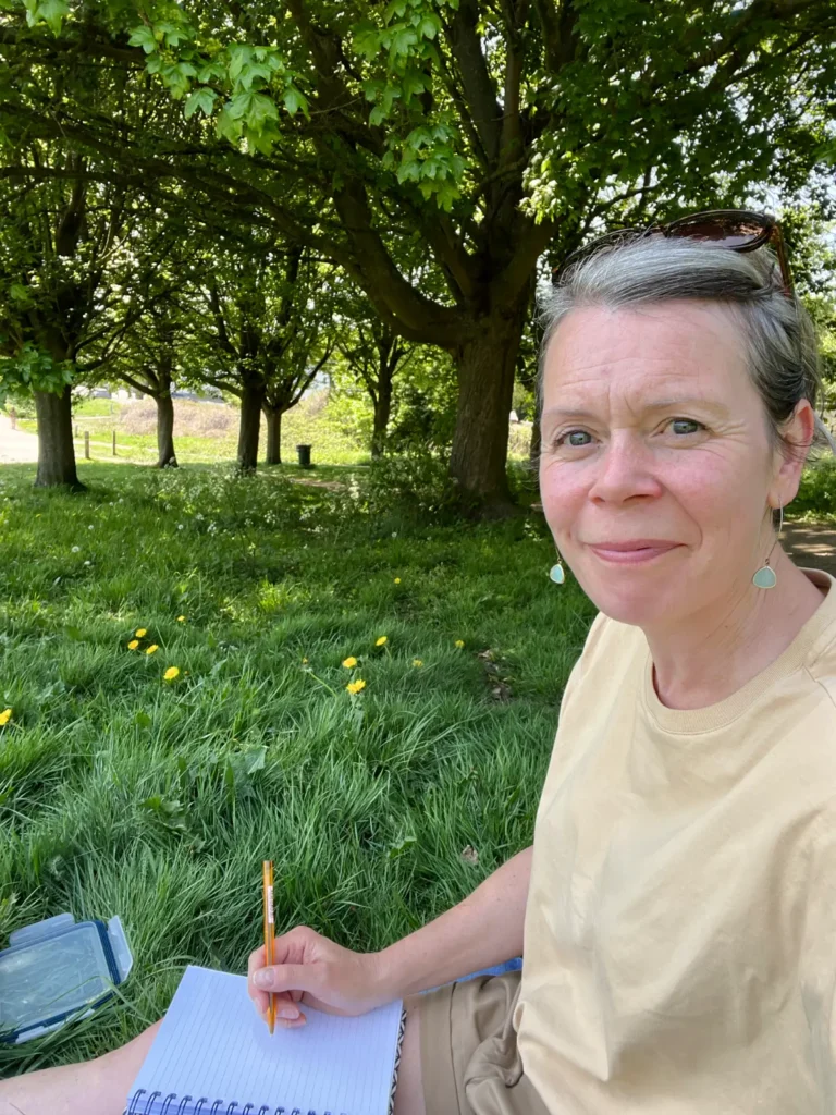TheKateOutdoors journalling in a green and luscious park